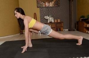 Cute brunette babe Aruna Aghora doing yoga in shorts and bare feet on ladyda.com