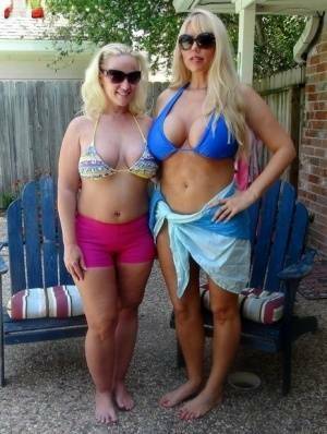 Blonde chicks Karen Fisher and Dee Siren loose their big tits from bikini tops on ladyda.com