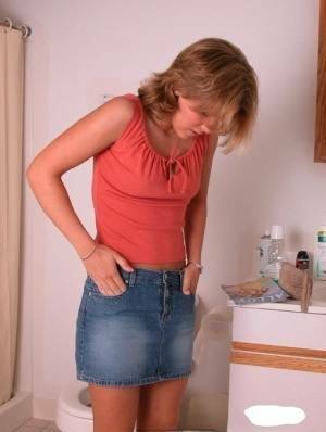Amateur girl Karen hikes her denim skirt in the bathroom to expose her panties on ladyda.com
