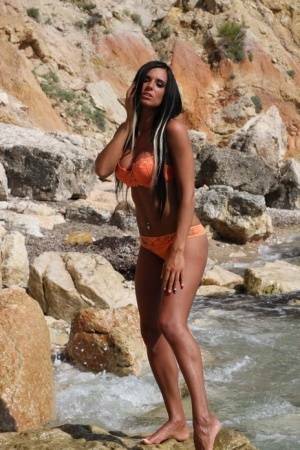 Leggy teen with long hair takes off her bikini in a fast moving stream on ladyda.com
