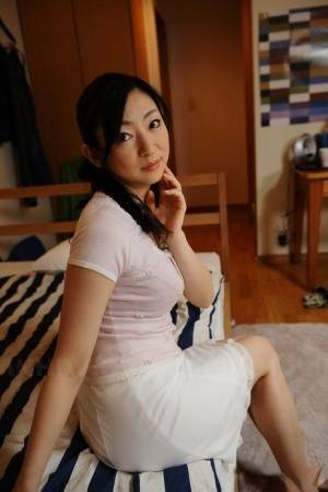 Slender mature Japanese woman Emiko Koike bends over to pose in white dress - Japan on ladyda.com