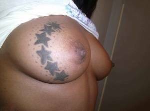 Ebony amateur takes self shots of her big tattooed boobs and bald vagina on ladyda.com