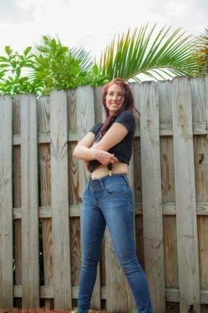 Hot redhead Andy Adams loses her t-shirt & jeans in the yard to pose naked on ladyda.com