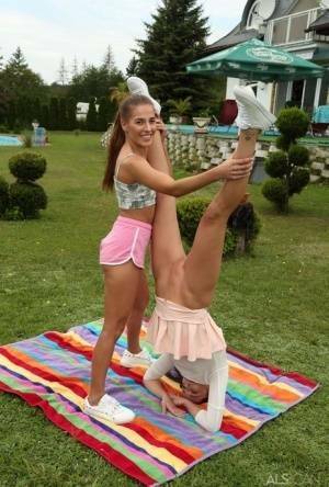 Young lesbians Eveline Dellai & Katy Rose fist pussies during sex on a lawn on ladyda.com