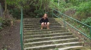 Natural redhead Chrissy Fox squats for a pee on a set of public steps on ladyda.com
