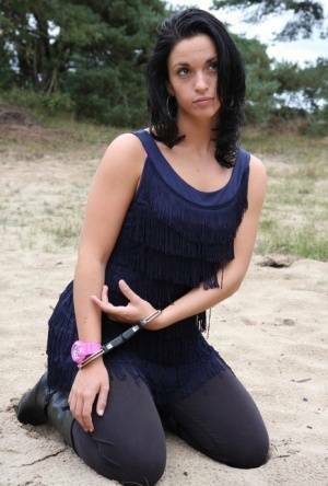Brunette girl Nora is handcuffed to a tree while wearing a pink G-Shock watch on ladyda.com