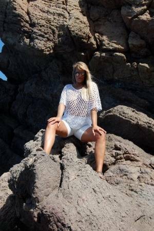 Blonde amateur Sweet Susi exposes her tits and ass on a rocks by the sea on ladyda.com