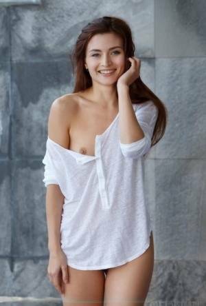 Petite teen divests herself of a white shirt to pose nude in and out of a pool on ladyda.com