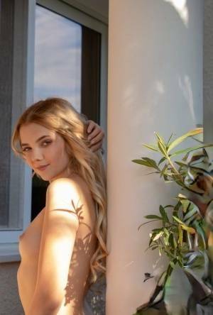 Young blonde Chanel Fenn shows her sexy ass while getting naked in a garden on ladyda.com