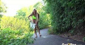 Blonde teen Daisy Lee takes a piss on a paved path through the woods on ladyda.com