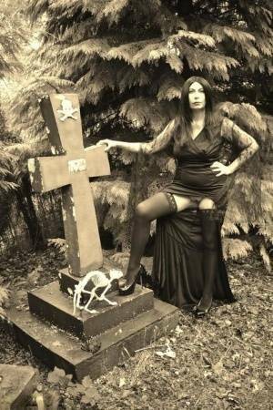 Goth girl Barby Slut bares her big tits and twat atop a casket in the woods on ladyda.com