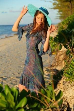 Teen beauty Nicole K modeling naked on beach wearing a sun hat on ladyda.com