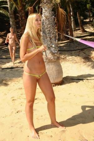 Natural blonde takes off her bikini to get totally naked on a beach on ladyda.com